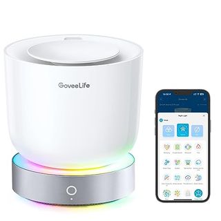 A white bowl shaped oil diffuser with a silver light up base. A phone beside it showing the app to control the light and time settings.