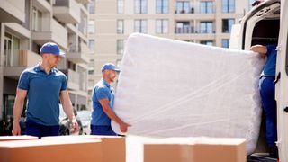 Three men moving a mattress
