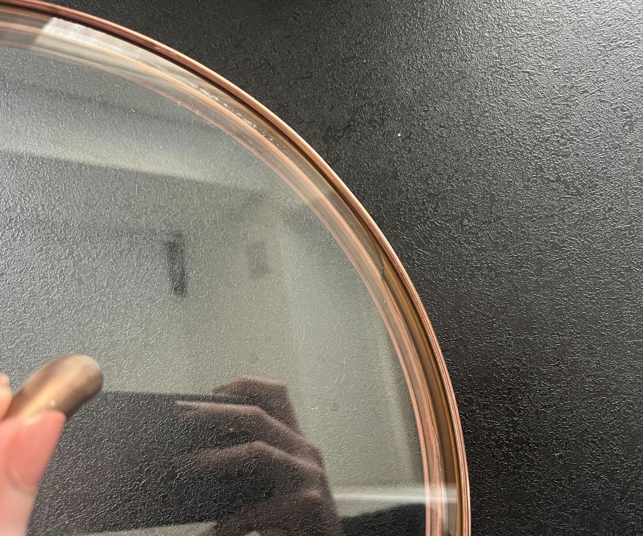 A close-up of water trapped in the rim of a glass lid.