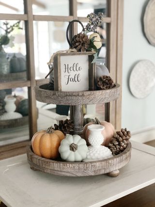 Fall decorated tier display with mini pumpkins and signage