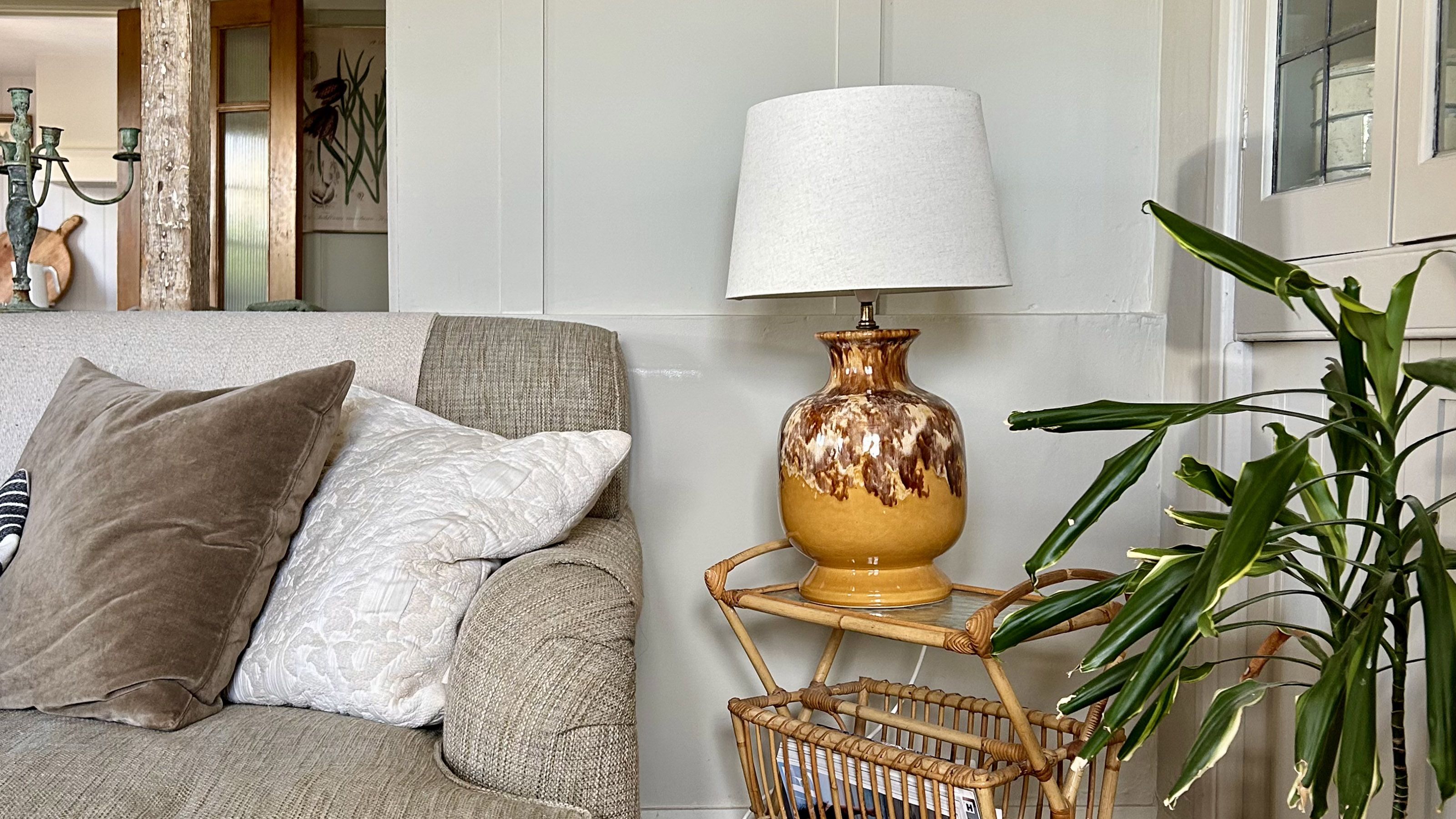 vintage lamp on a rattan side table next to a grey sofa