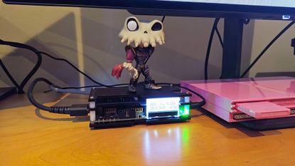 OSSC with Sir Dan MediEvil figure on top next to pink PS2 Slim.