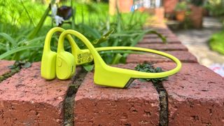 Suunto Sonic headphones on a red brick garden wall outside