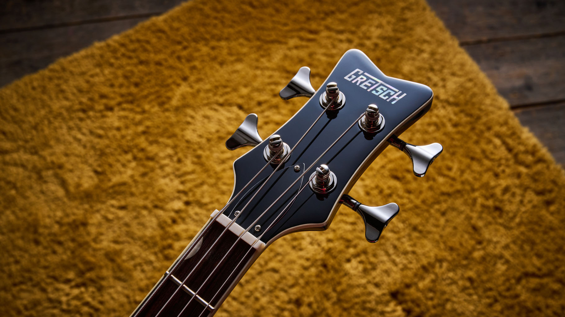 Gretsch Electromatic CVT Bass Double-cut: the retro-styled cream-colored four-string is pictured in close-up against a shaggy brown carpet.