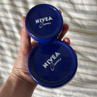 Katie Thomas holding two tubs of nivea creme