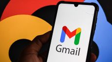 Gmail logo and branding pictured on a smartphone screen with company colors and branding also pictured in background.