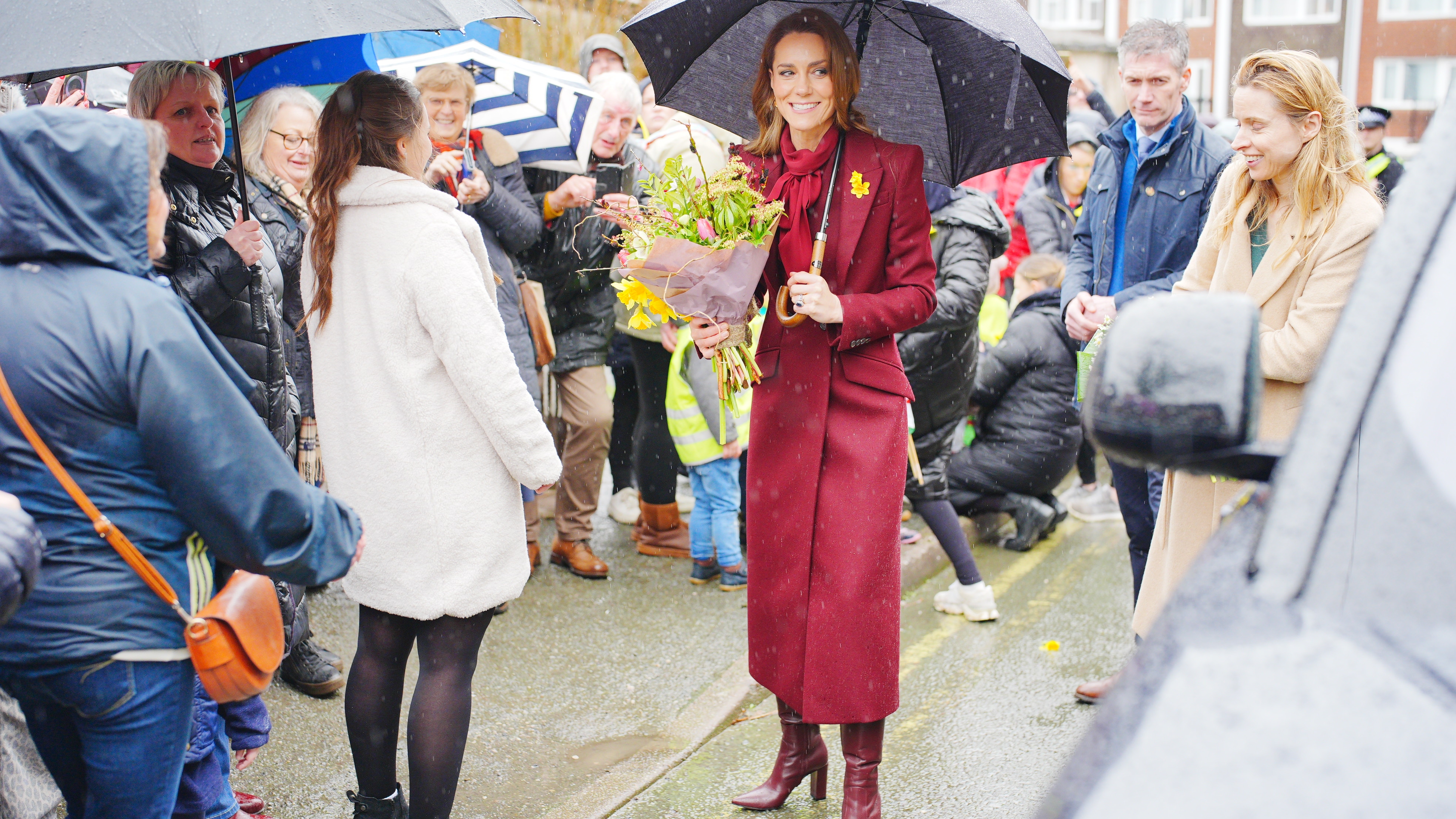 Catherine, Princess of Wales shelters from rain under a umbrella whilst meeting members of the public during a visit to the Hanging Gardens on February 26, 2026