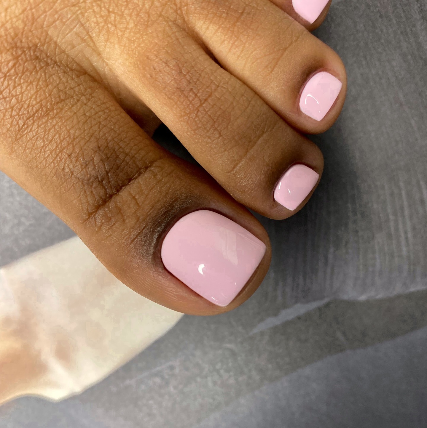 Uma mulher com uma pedicure quadrada e rosa