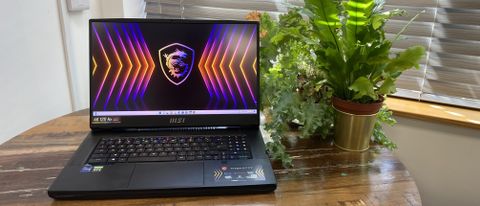 MSI GT77 Titan laptop with screen open on a wooden table