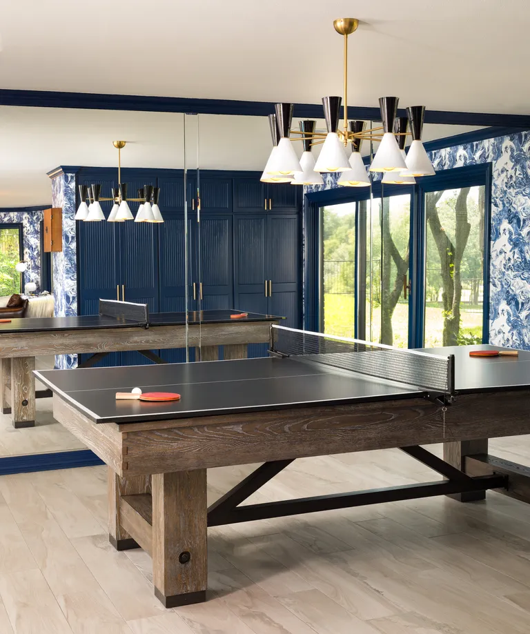 games room with table tennis table, blue cabinetry, blue wallpaper, retro pendant light, glass doors to garden, wall of mirrors