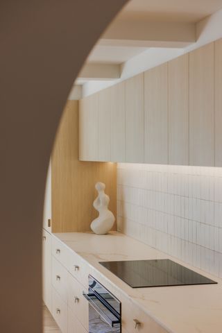 A kitchen with ceiling beams and light wood cabinets