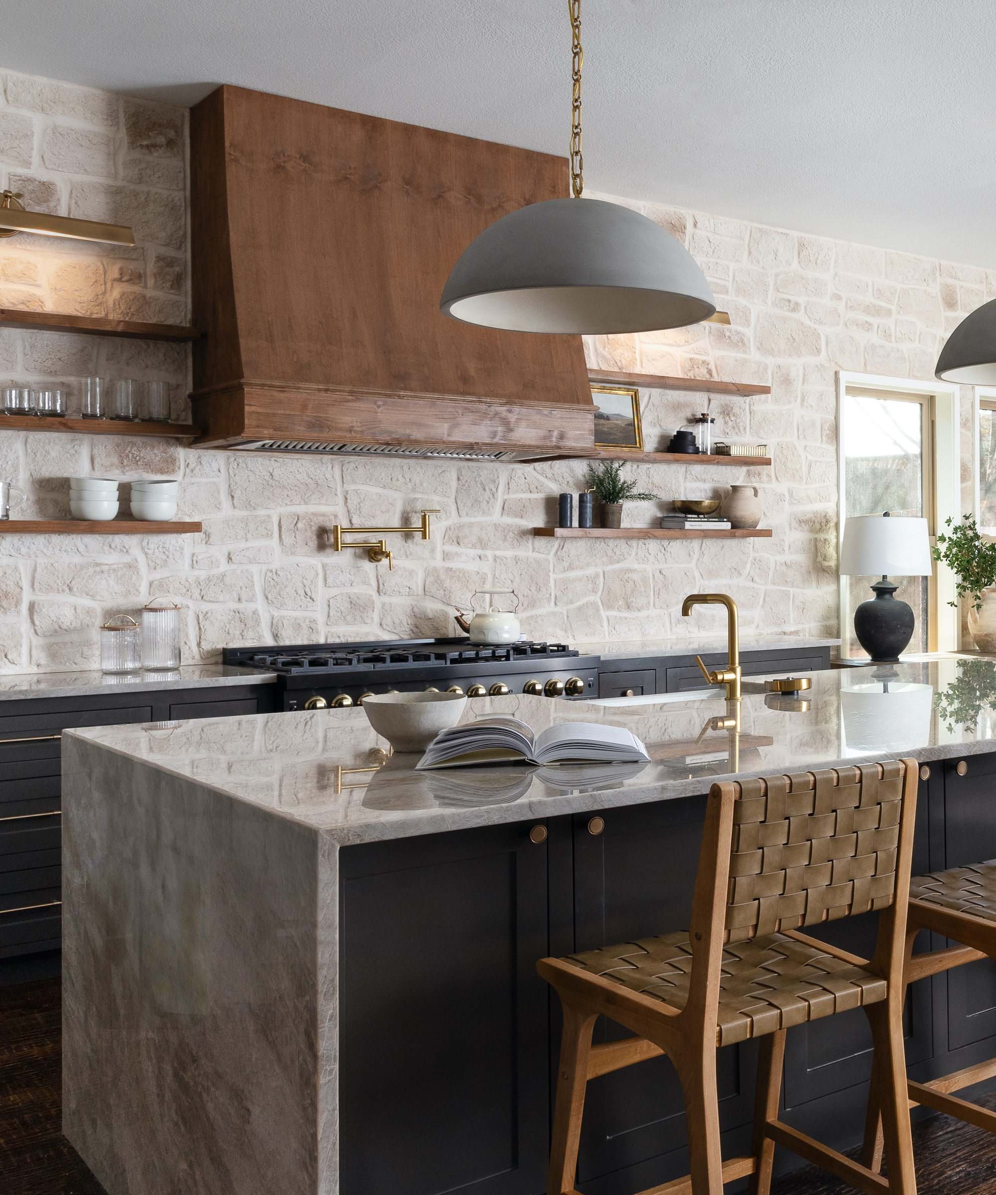 dark kitchen with marble tops and exposed stone wall