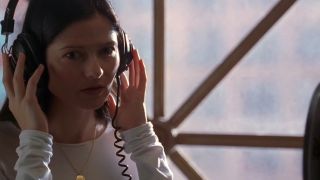 Jill Hennessy listening to something on headphones in Crossing Jordan.