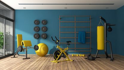yellow gym equipment in a blue wall home basement gym - getty