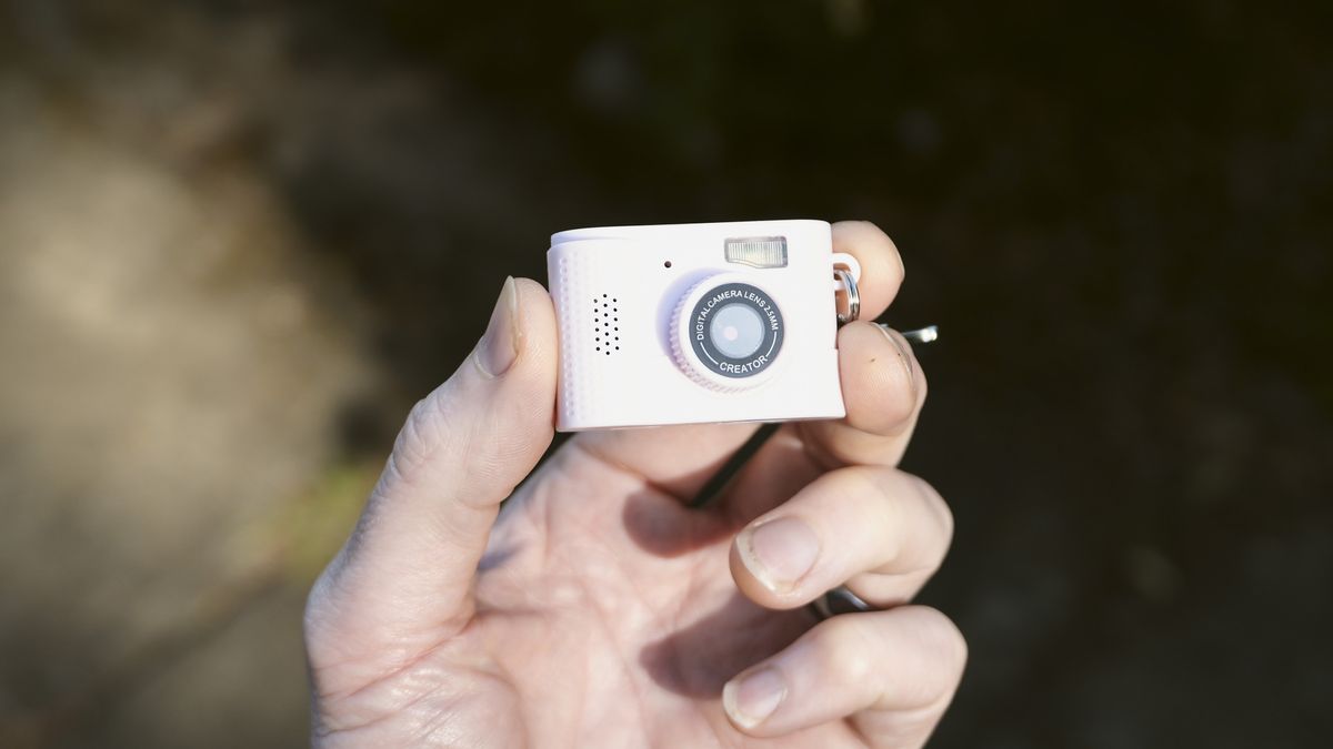 Miniature pink keychain camera, the 'Photo Creator Mini Digital Camera series 3', in user's hand
