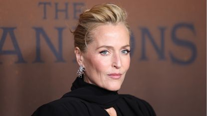  Gillian Anderson is pictured with her hair in an updo and wearing winged eyeliner and mascara, as well as a black scarf and blazer at Netflix's "The Abandons" Los Angeles Premiere at Netflix Tudum Theater on December 03, 2025 in Los Angeles, California. 