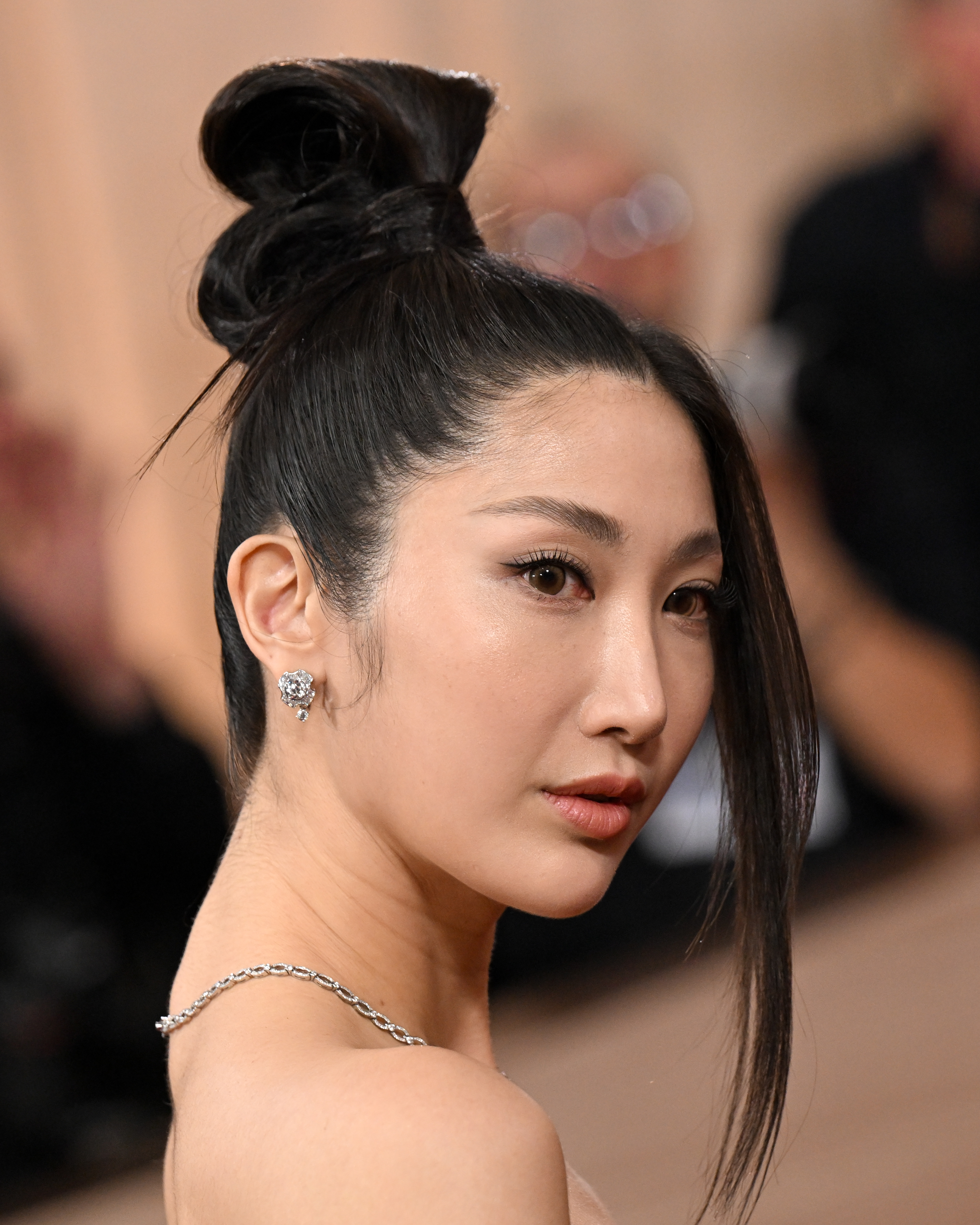 an asian woman with dark hair pulled in to a high bun