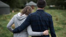 Couple with backs to camera, arms around each other's waists