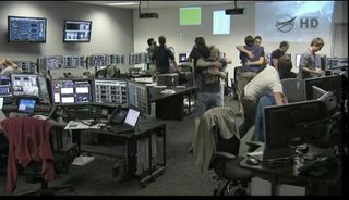 SpaceX launch controllers in Cape Canaveral, Fla. react to the successful launch of the Falcon 9 rocket carrying the Dragonc apsule into orbit.