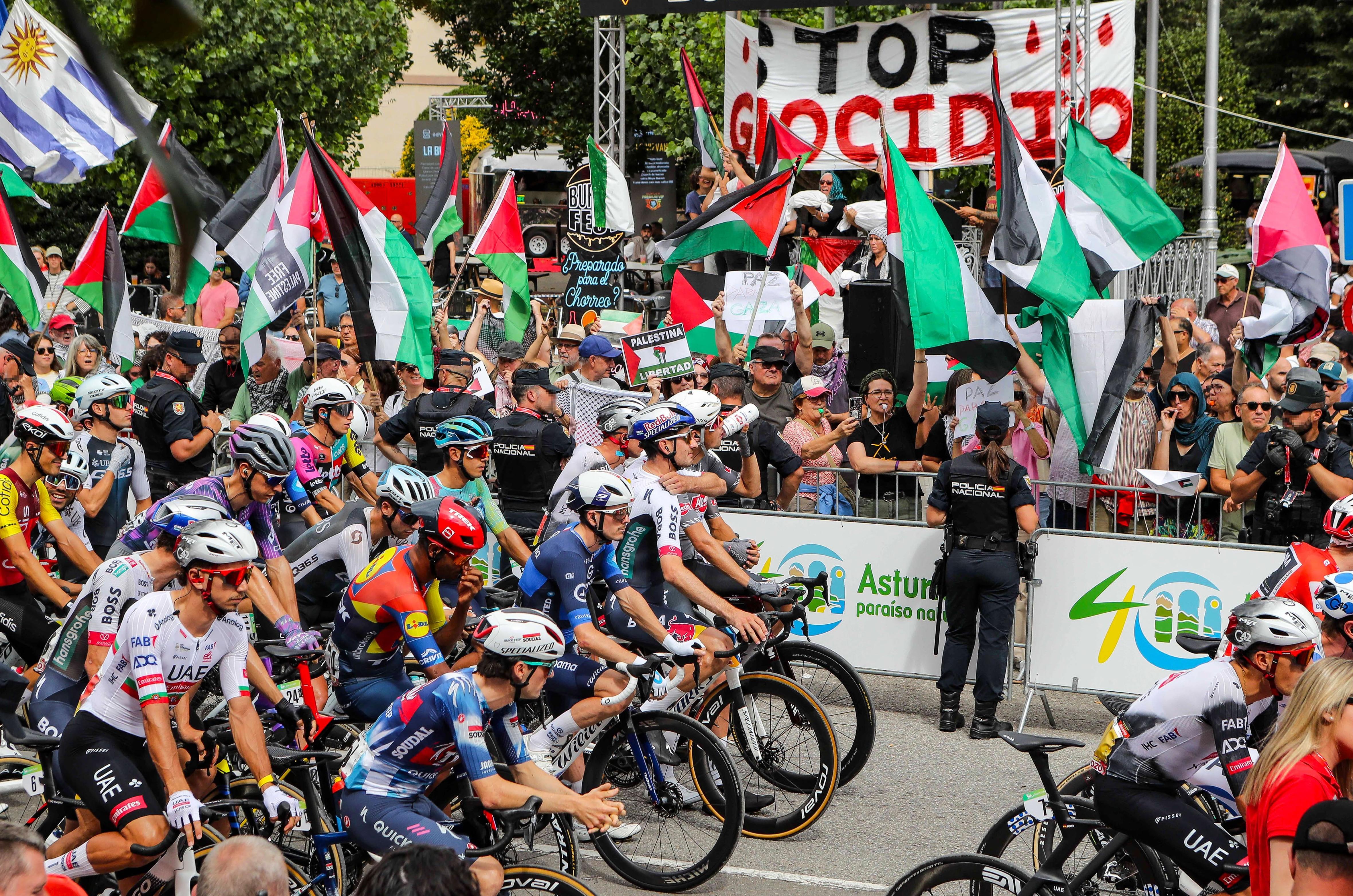 Vuelta start line with crowds holding many Palestine flags
