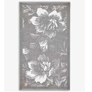 Grey and white floral print bath mat on a white background