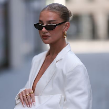 Refy founder Jess Hunt wearing white blazer and sunglasses with best Refy products