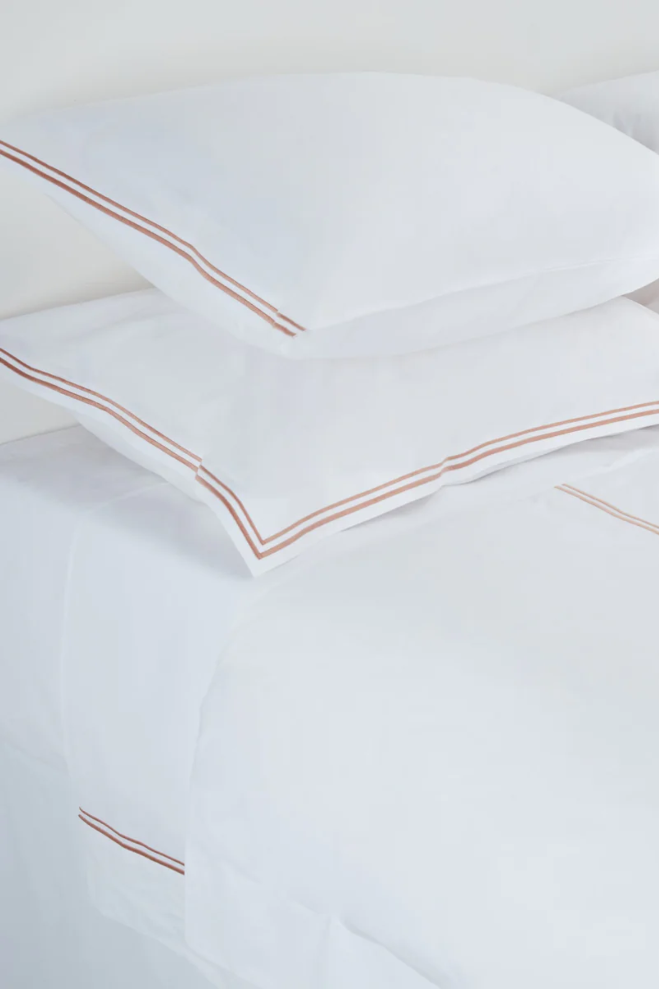 White bedding with pink/beige double piping