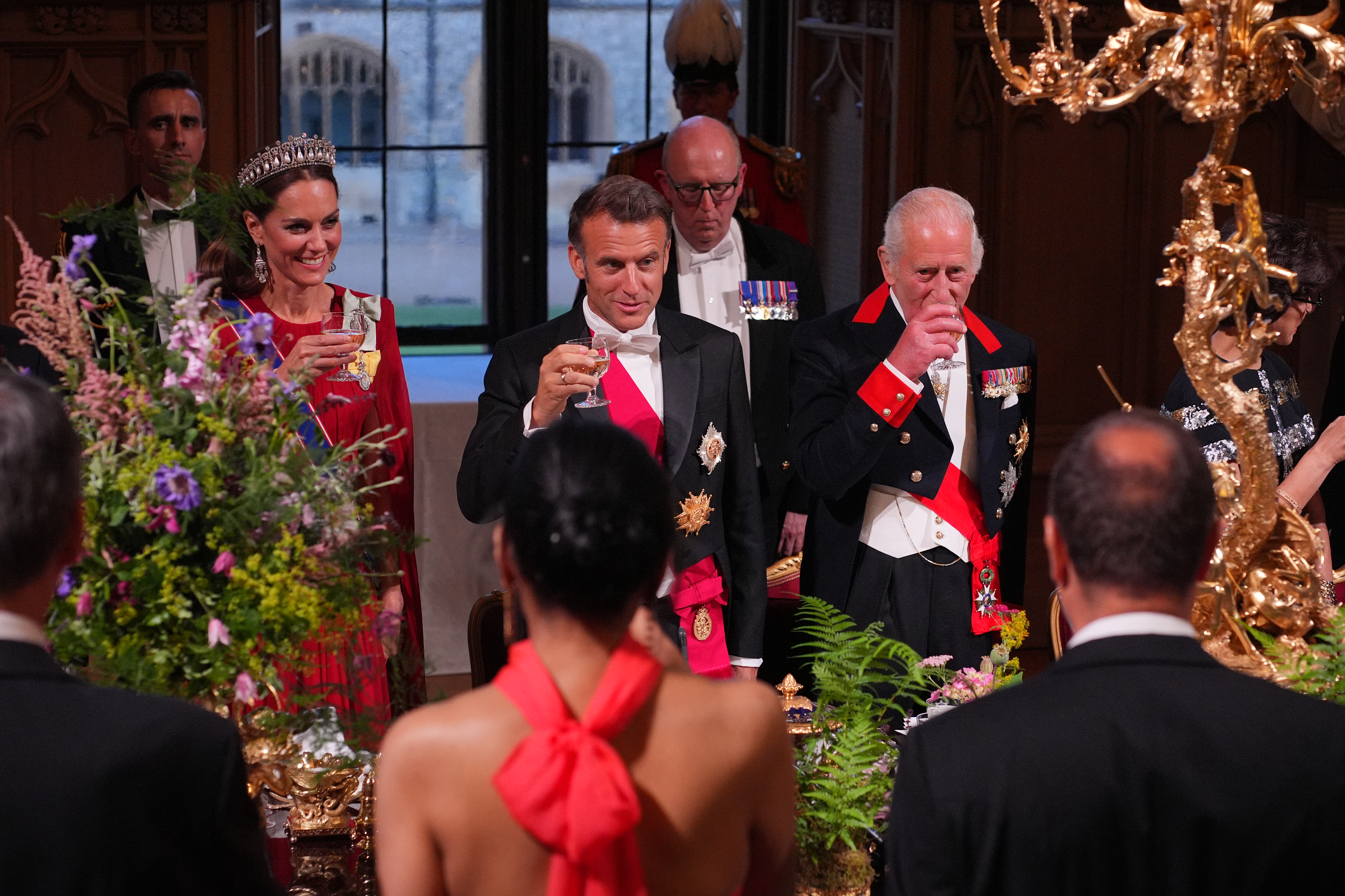 Kate Middleton raising a glass next to Emmanuel Macron and King Charles at a state banquet