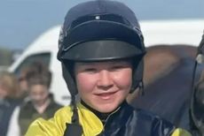 Alice Procter wearing black and yellow silks and a safety helmet with her googles secured above the peak of her hat sillk
