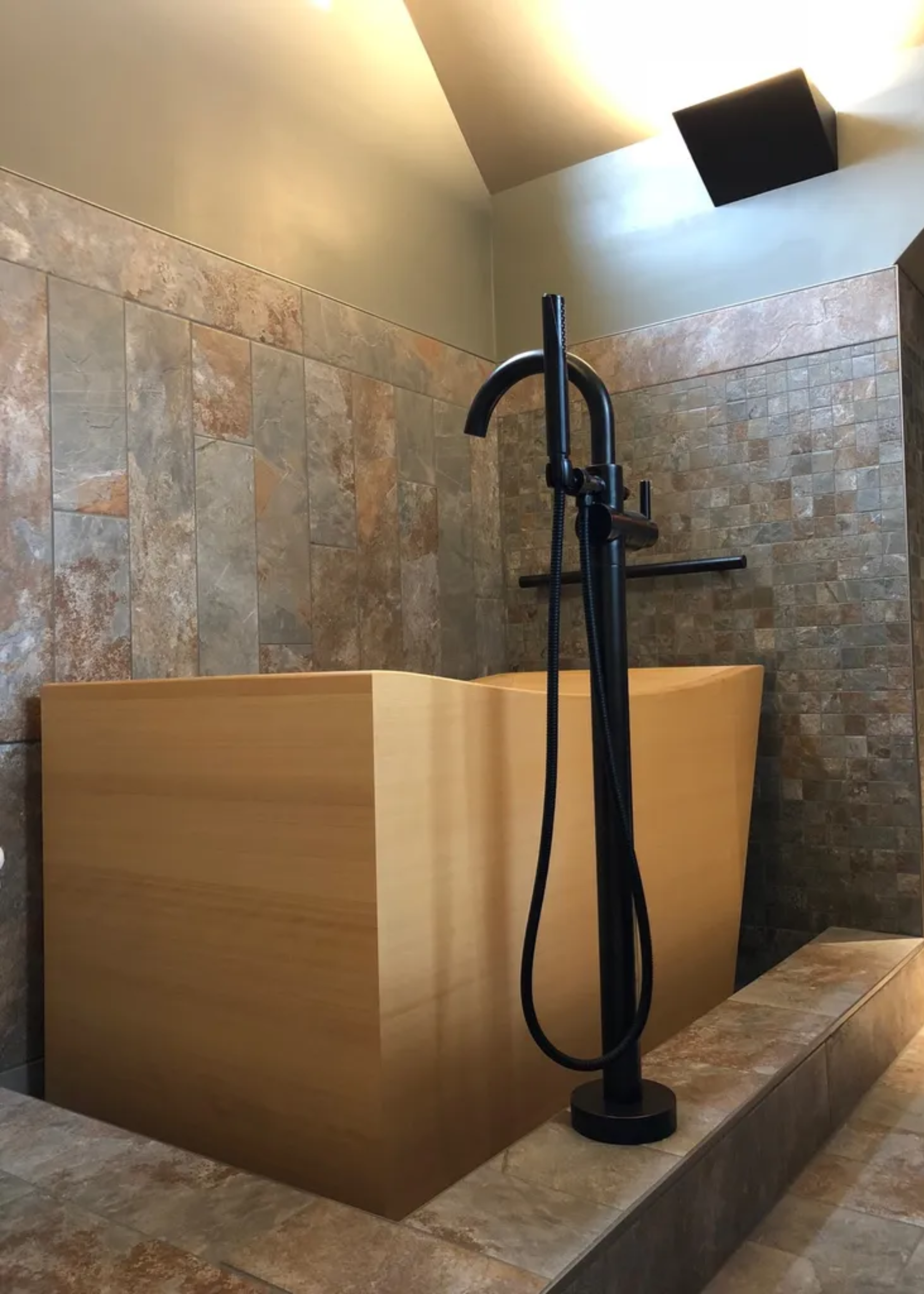A traditional Japanese soaking tub in a tiled bathing nook