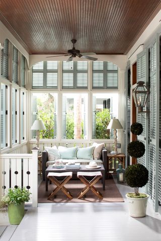 Window treatment ideas with shutters on a porch