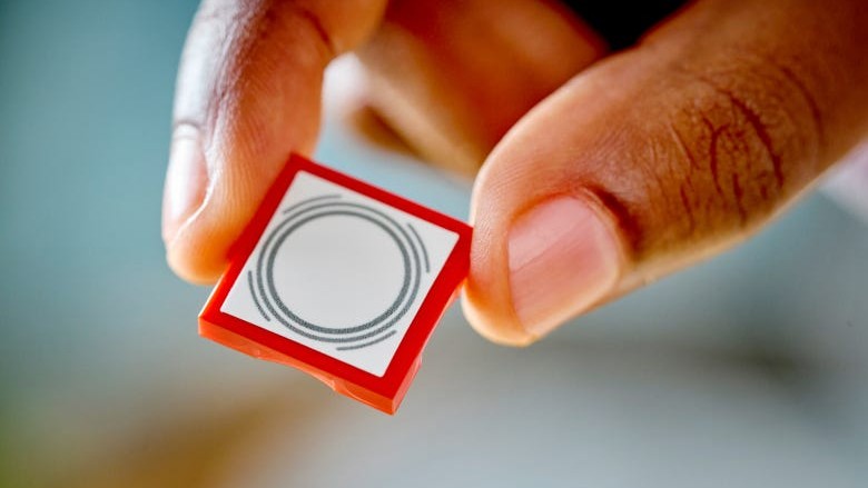 A close up of someone holding a Lego Smart Tag