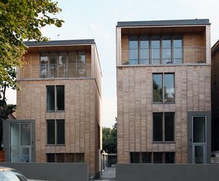 twin apartment towers that sit in front of a single-storey mews development resplendent in a crisp wooden skin