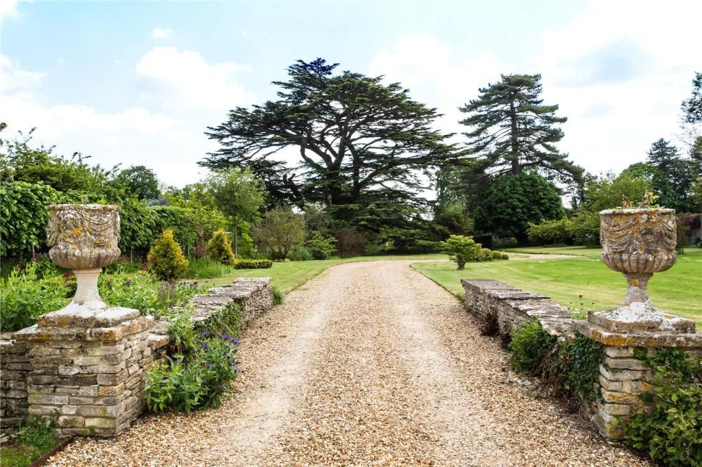 A gravel pathway leading towards the house with grass lawn either side