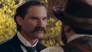 Kurt Russell with a mustache looking tough in Tombstone