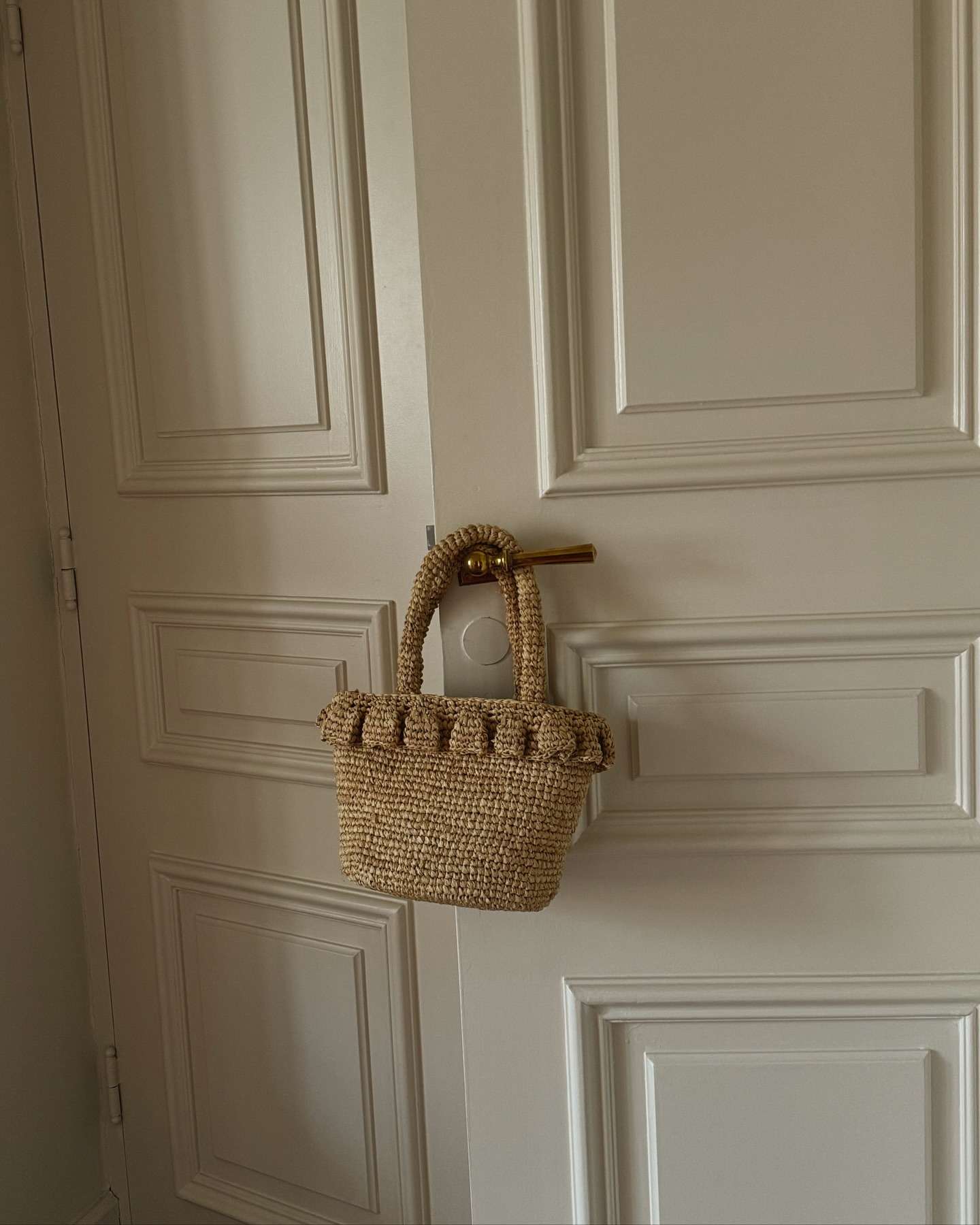 @lefevrediary photo of j.crew raffia tote hanging on door handle.