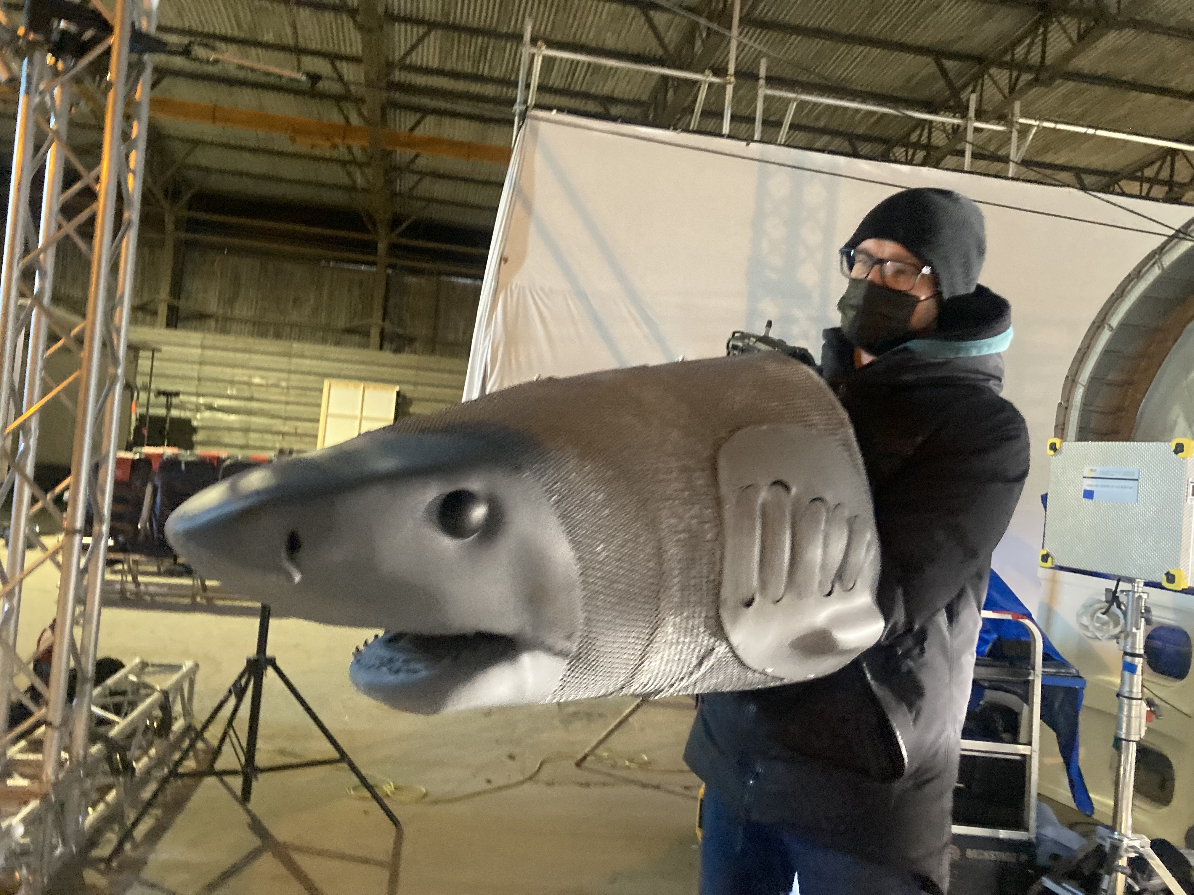 A person with their hands inside a puppet shark