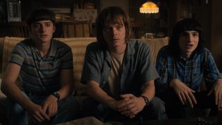 Mike, Will and Jonathan stare at someone off camera in Stranger Things season 4