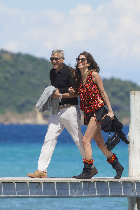 Amal Clooney in Saint-Tropez wearing boots and a mini skirt