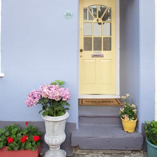 small front porch ideas, tiny front porch, yellow front door, blue grey masonry, plants