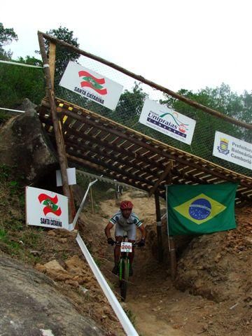 A cross country competitor passes under the downhill track.