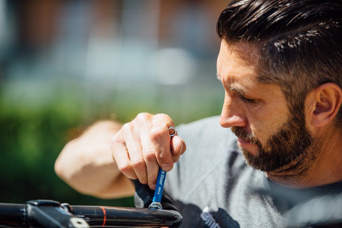 A BMC mechanic tinkers with a rider's bars