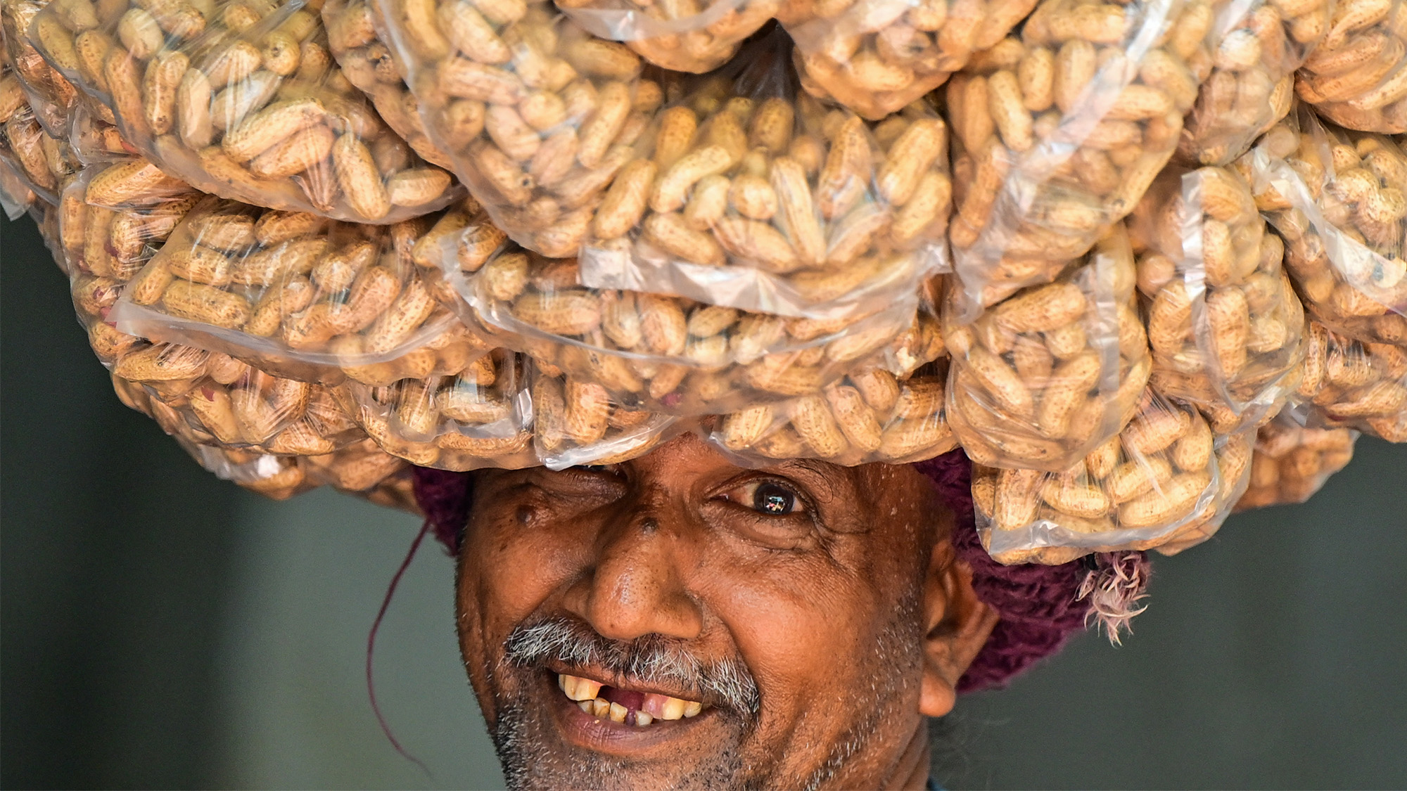 A smiling vendor sells peanuts along a road in Colombo, Sri Lanka