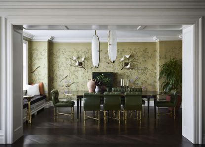 A dining room with a green wallpaper