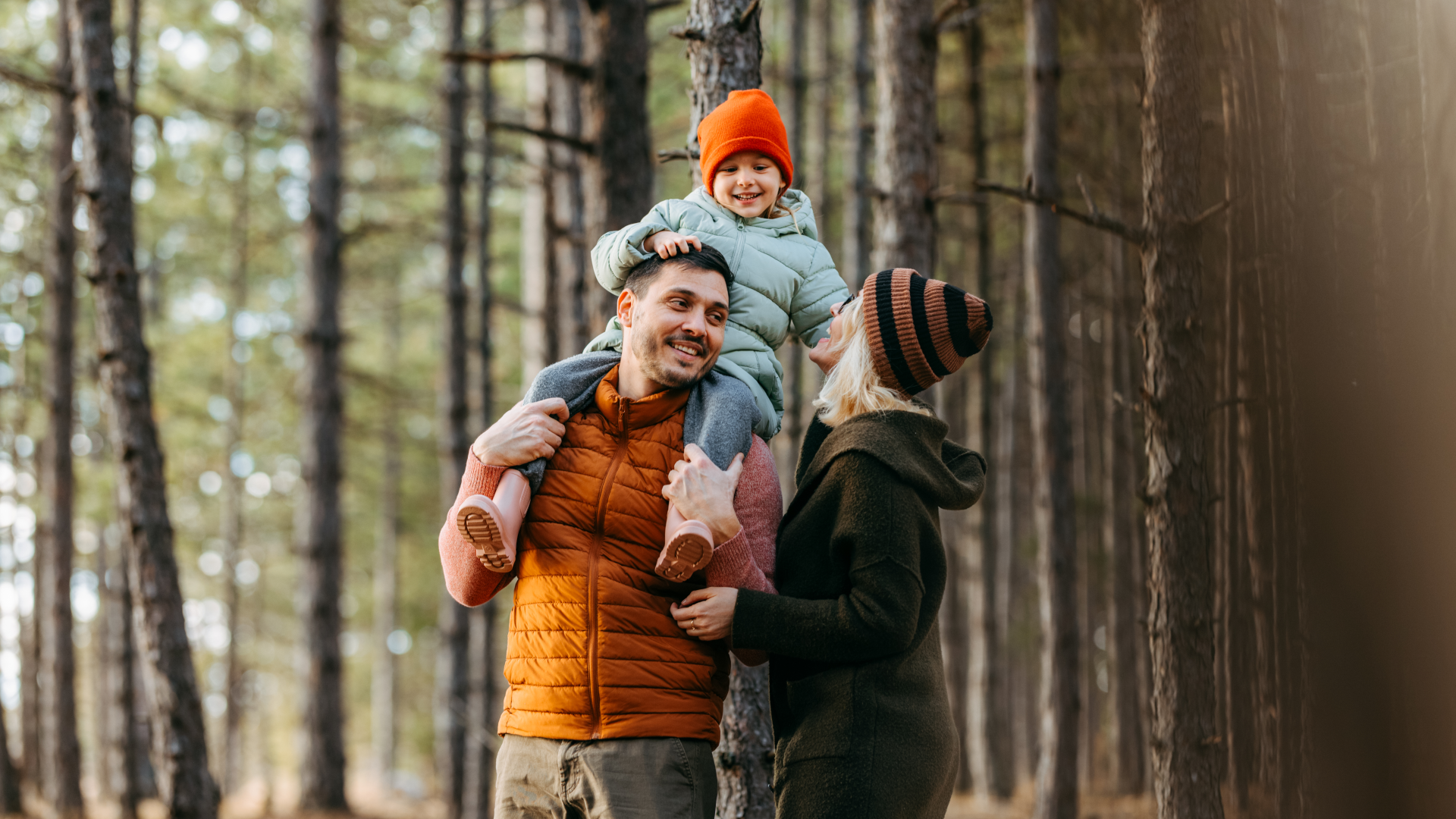 A family walking through the woods during autumn