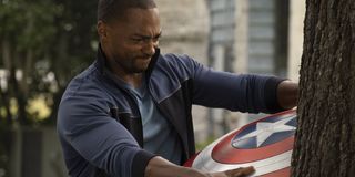 Sam Wilson/Falcon (Anthony Mackie) pulling Captain America's shield out of a tree in The Falcon And The Winter Soldier