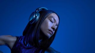 A person wearing the Bose QuietComfort Ultra headphones in blue.