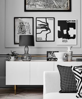 Living room with white sideboard, white couch and black and white artwork on wall