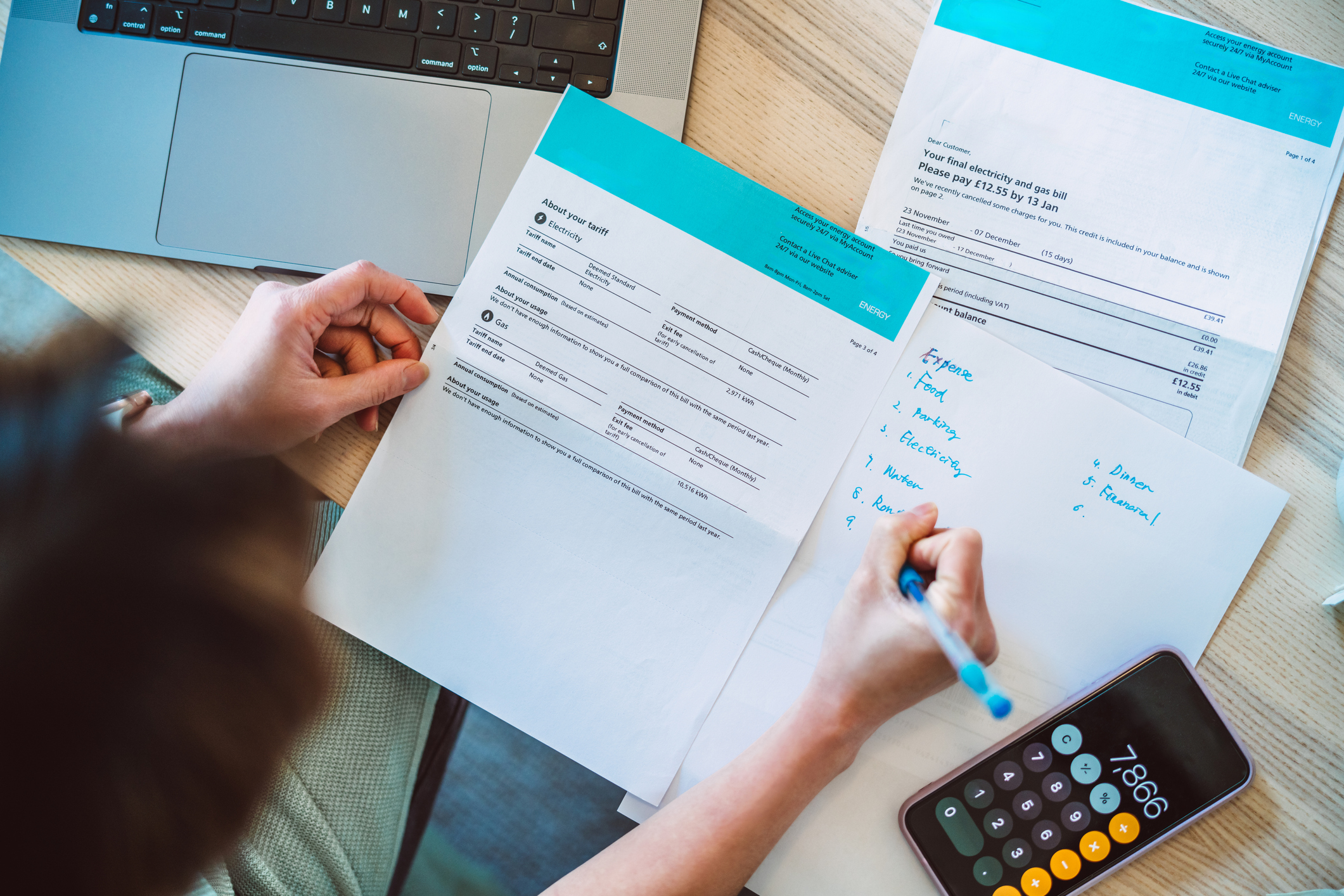 Person looking at their energy bills with a calculator