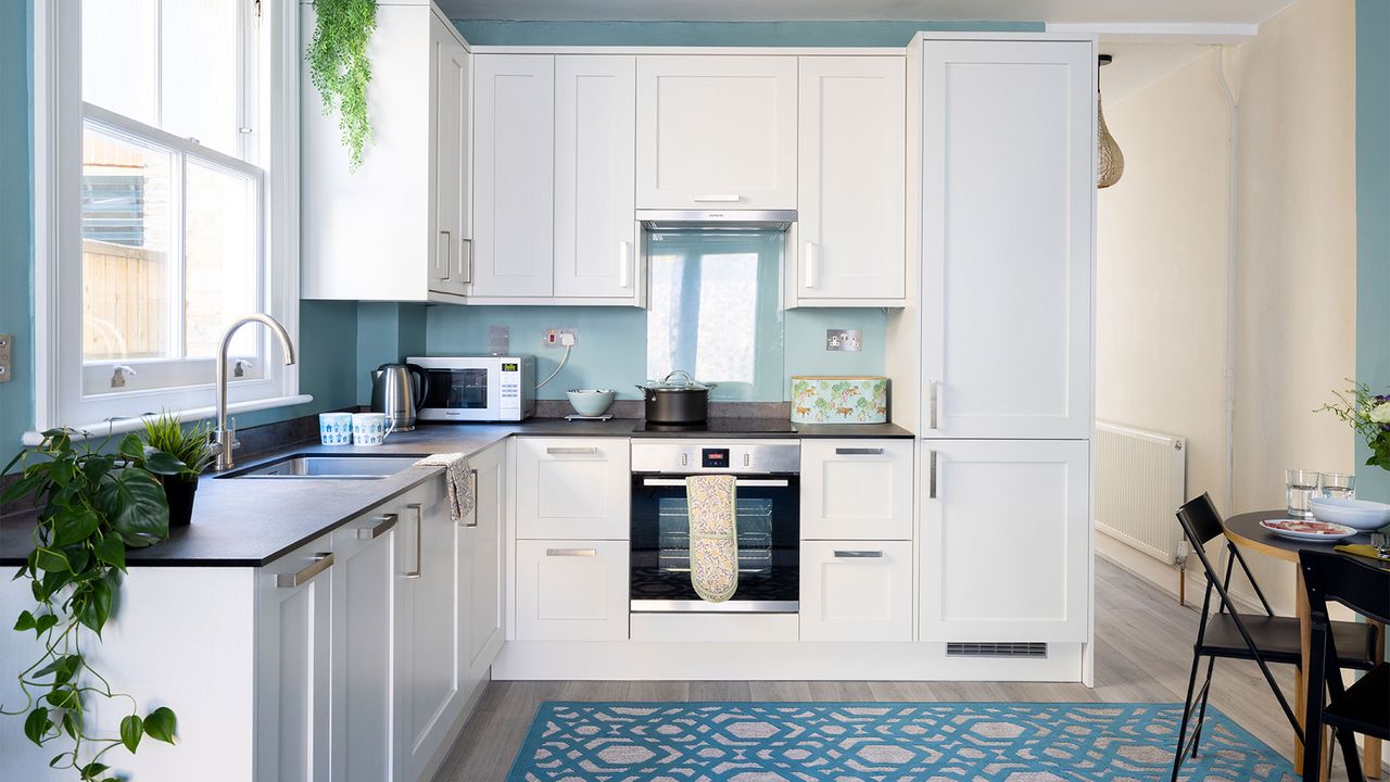 white kitchen with blue walls and blue rug